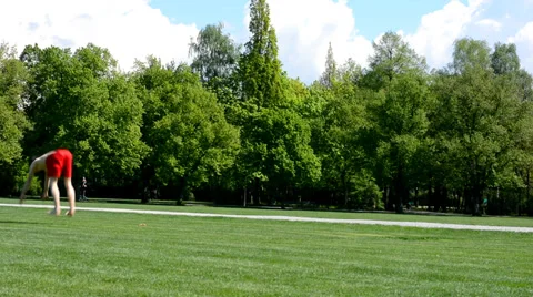 Young boy jumps back flip in the park Stock Footage 37599496