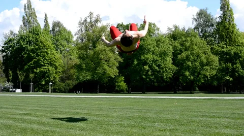 Young boy jumps back flip in the park Stock Footage 37599510