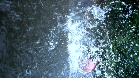 A young boy jumps from a mountain into a river Video stock 281717120
