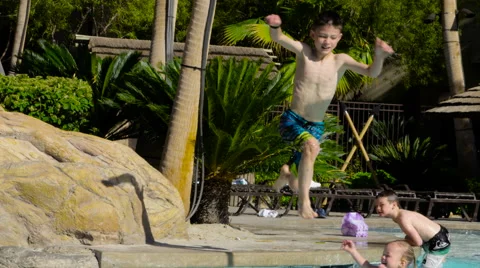Young boy jumps into pool in slow motion Stock Footage 62480219