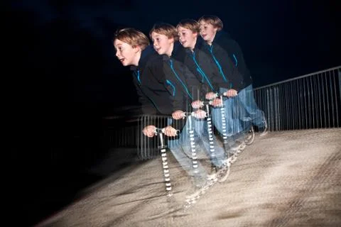Young boy jumpy with his scooter by night Stock Photos