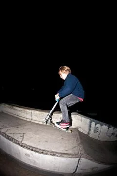Young boy jumpy with his scooter by night Stock Photos