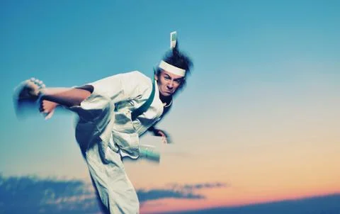 Young boy in karate uniform training at sunset Stock Photos