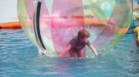 Young boy kids in zorb bubble ball swimming in pool Stock Footage 66099078