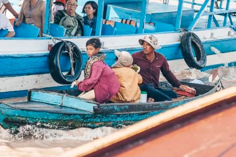 Young boy with large python snake on the wooden boat at the Tonle Sap lake in 스톡 사진