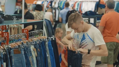 A young boy in a large store chooses new clothes for himself Stock Footage 83214038