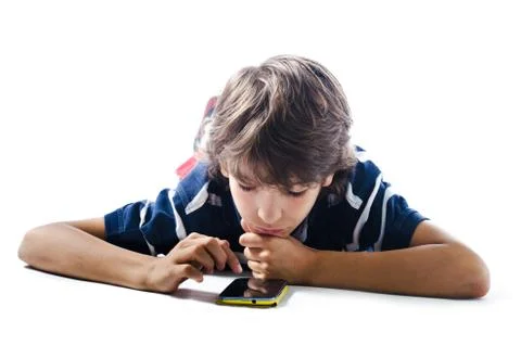 Young boy laying on the floor using cell phone Stock Photos