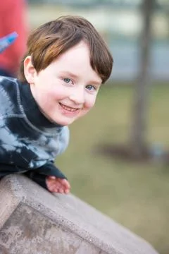 Young boy leaning over looking and smiling Stock Photos
