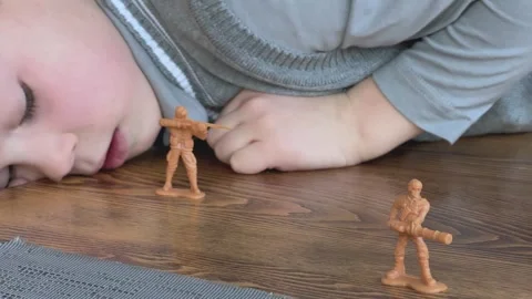Young Boy Leaning On Table Playing With Toy Soldiers Close Up Child Hands Vídeos de archivo 336321199