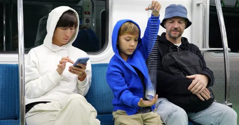 Young boy learn how to play with slinky toy, family at subway train Stock Footage 303986320