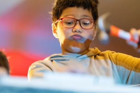 Young boy learning building skills with a hammer 写真素材