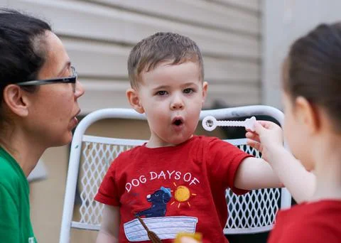 Young boy learning how to blow soap bubbles Stock Photos