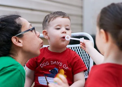 Young boy learning how to blow soap bubbles Stock Photos