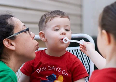 Young boy learning how to blow soap bubbles Stock Photos