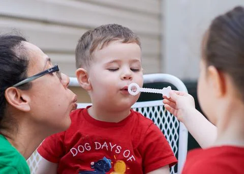 Young boy learning how to blow soap bubbles Stock Photos