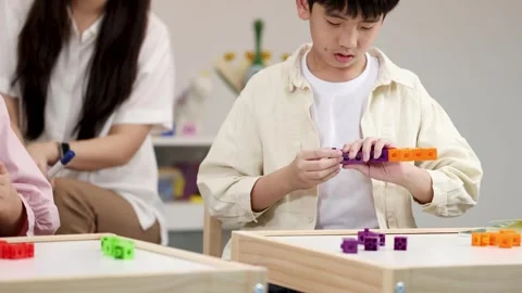 Young Boy Learning Math with Colorful Interlocking Plastic Counting Blocks Vídeo Stock 328346130