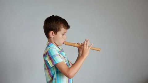 Young boy learning to play the flute or recorder Stock Footage 138656390