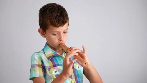 Young boy learning to play the flute or recorder Stock Footage 138695587