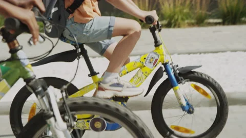 Young Boy Learning to Ride Bicycle Outdoors with Friend Stock Footage 235634142