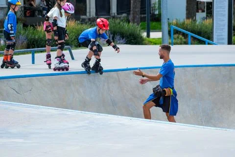 Young Boy Learning Roller Skating With Coach at Skatepark Stock Photos