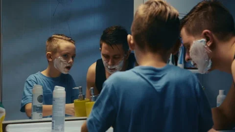 Young boy learning to shave helped by his father Stock Footage 88193132