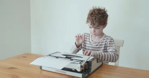Young boy learning to type on an old portable typewriter Video stock 127965605