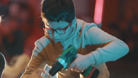 Young boy learning woodworking using power drill Stock Footage 329544612