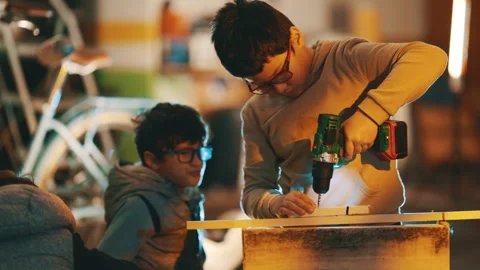 Young boy learning woodworking using power drill Stock Footage 329559164