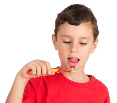 Young boy licking tooth paste from teeth brush 库存照片