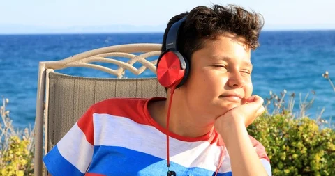 Young boy listeneng to music at the nature 4 Stock Footage 92446853