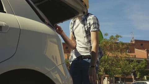 A young boy is loading his suitcase in the car and travelling with some friends Stock Footage 155249086