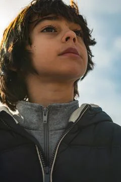 Young boy looking up against sky, contemplating future Fotos Stock