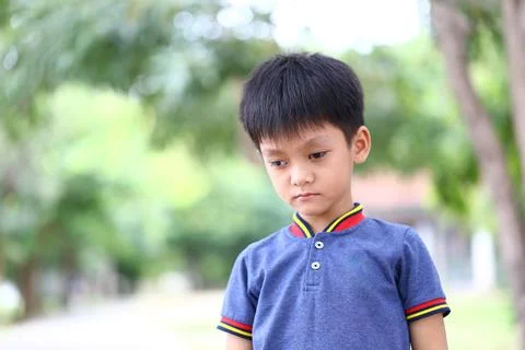 Young Boy Looking Down in Tranquil Outdoor Setting Stock Photos