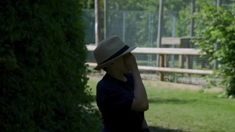 Young boy looking forward wearing a straw hat Видео 243097657