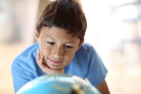 Young boy looking at a globe Stock Photos
