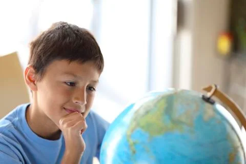 Young boy looking at a globe Stock Photos