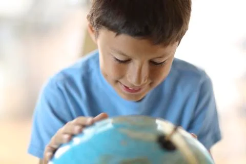 Young boy looking at a globe Stock Photos