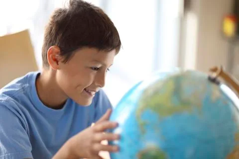 Young boy looking at a globe Stock Photos