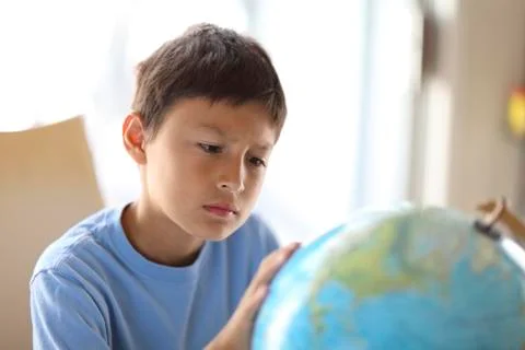 Young boy looking at a globe Stock Photos