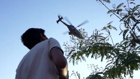 Young Boy looking up at Helicopter passing - Army Chopper flying over - Air Show 스톡 동영상 220169834