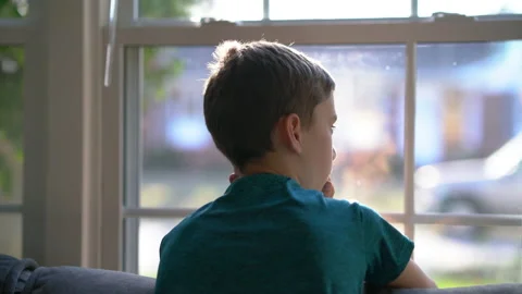 Young Boy Looking Outside Through Window Video stock 149897618