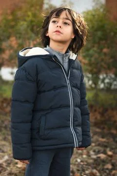 Young boy looking up pensive while standing outdoors Stock Photos