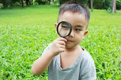 Young boy looking through magnifying glass Stock Photos
