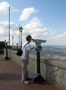Young boy looking through a telescope on the observation deck in San Marino Stock Photos