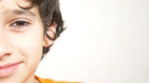A young boy looks at the camera and smiling. 4k. close-up, half face, copy space Stock-Footage 87498259