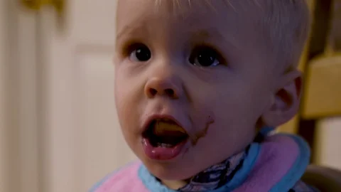 Young boy looks at camera as he eats his breakfast Stock-Footage 105180002