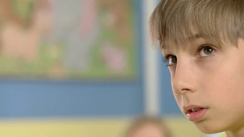 Young boy looks at something while the hairdresser cut his hair Stock Footage 77767323