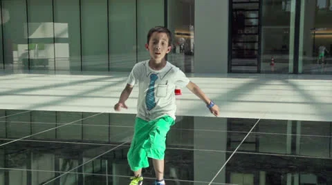 Young boy makes a jump on mirror floor. Stock Footage 24738483