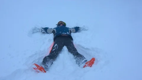 Young Boy Making a Snow Angel in Fresh Powder Stock Footage 102928952