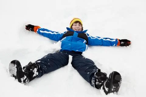 Young Boy Making Snow Angel On Slope Stock Photos